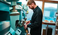 Der Orthopädieschuhemacher schleift einen Maßschuh an der Maschine